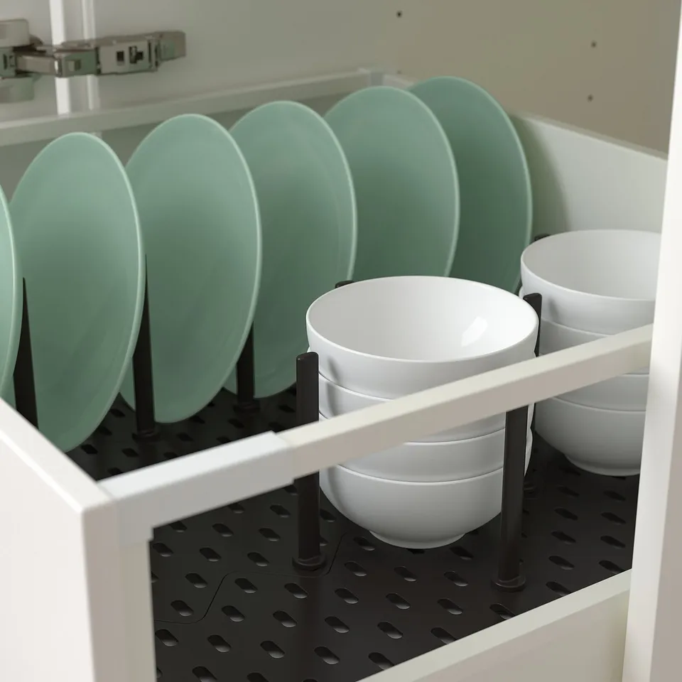 Organised drawer with green plates and white bowls held by adjustable pegs.