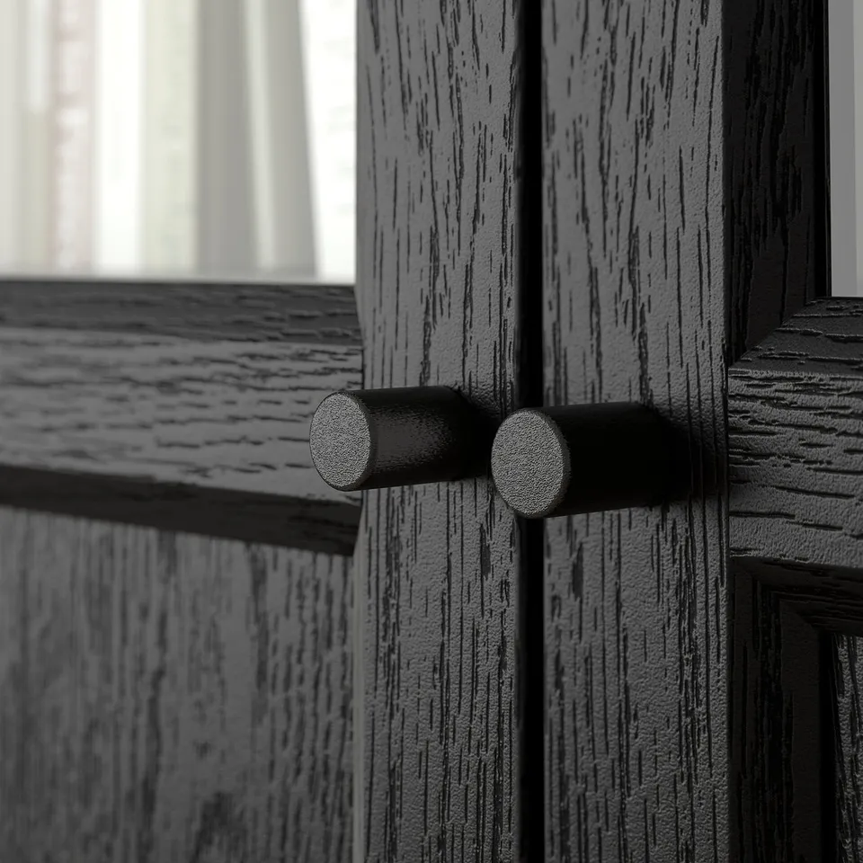 Wooden BILLY bookcase door detail, showing dark metal handles and textured wood grain.