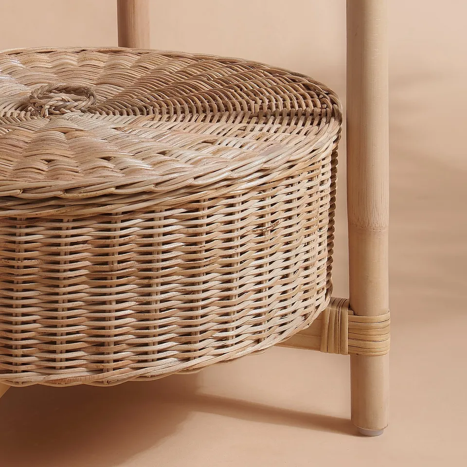 Wicker side table with intricate, handwoven design, natural wood legs.