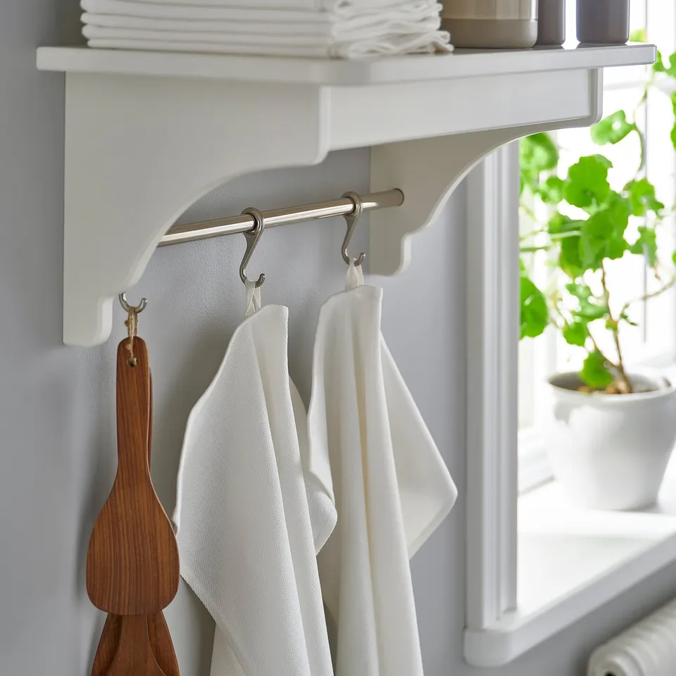 Kitchen shelf with hanging towels, wooden spatula, and plant, showing RÖDSPÄTTA towel packs functionality.
