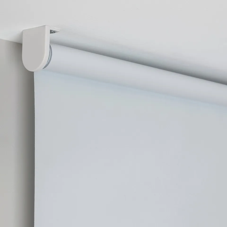 Roller blind mounted on wall, showing light block feature and cordless operation.