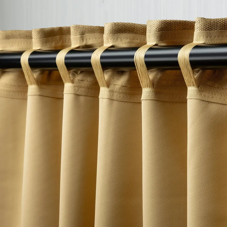 Curtains with room-darkening fabric, hanging from rod with hooks that allow light blocking and privacy.