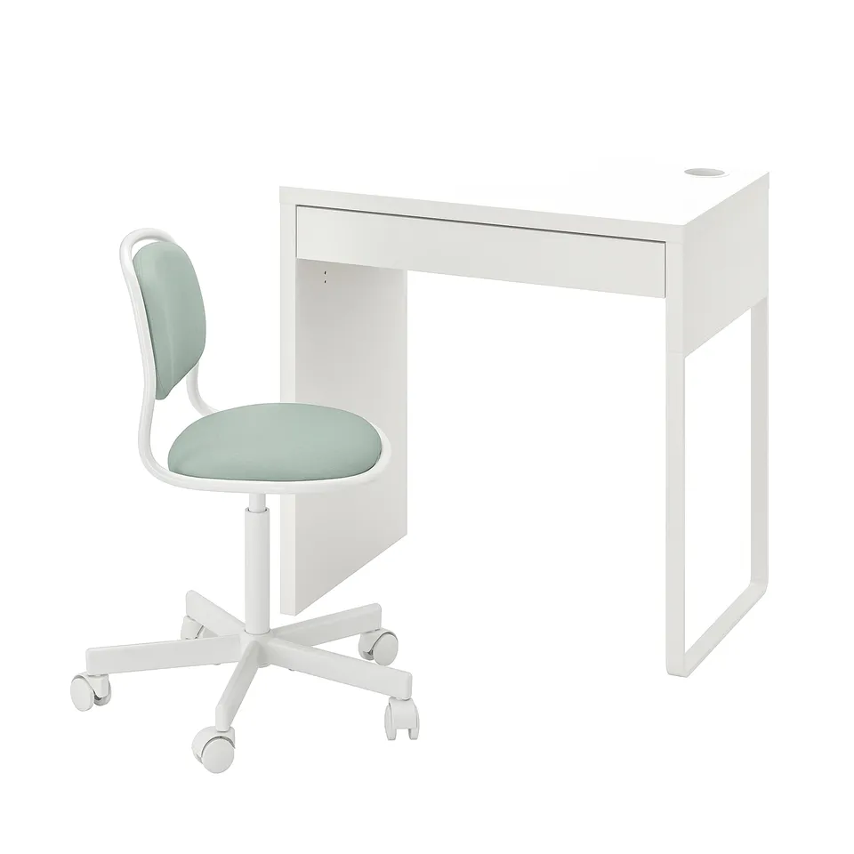 White desk with single drawer and round hole. Light green cushioned chair, white base with wheels.