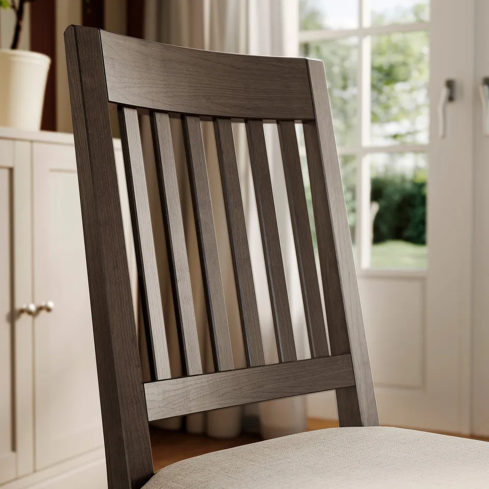 Dark wood chair with vertical slats and light beige cushion, designed for comfort and modern rustic style.