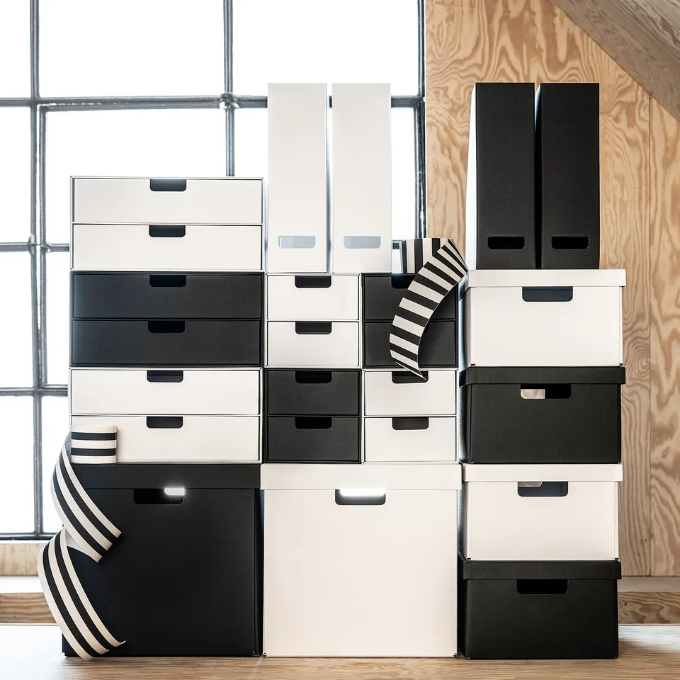 Stacked FJÄDERHARV boxes in black/white, varying sizes, some with handles. Ideal for storage in kallax shelves.