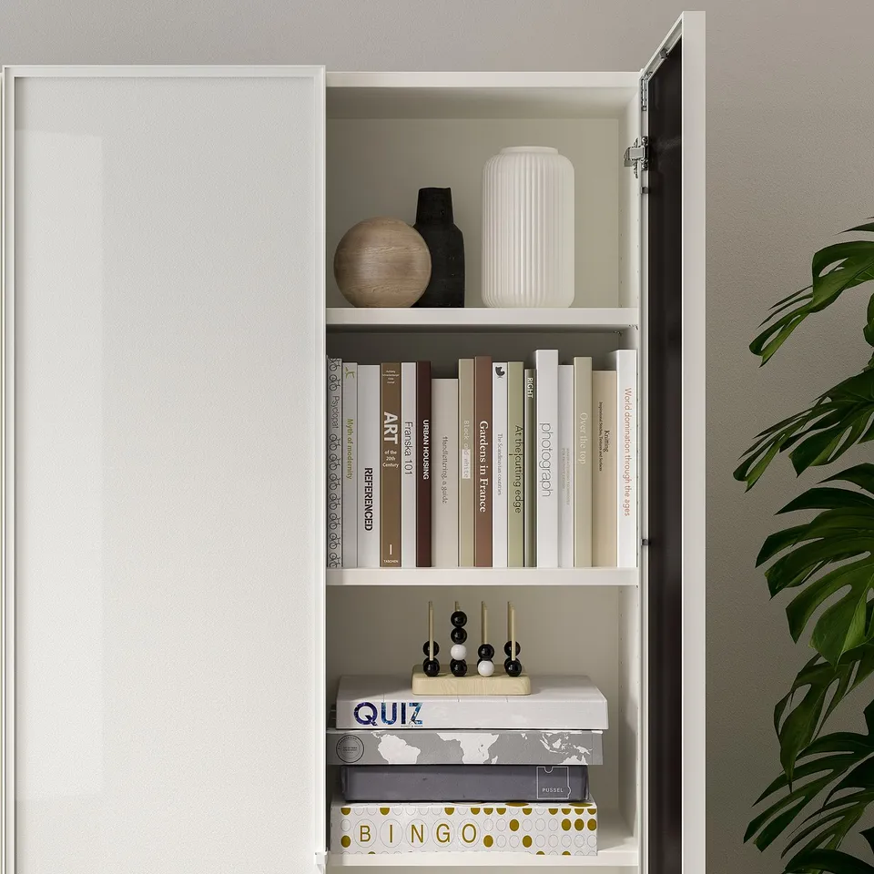 Closed bookcase with glass door displaying books, decorative items, and board games.