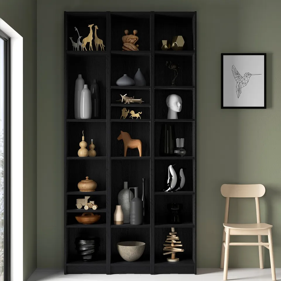 Black BILLY bookcase with vases, art, and chair.