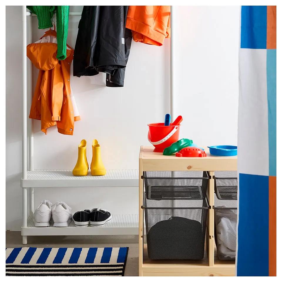 Entryway scene: coats, boots, and kids toys on shelves. Colourful rug, striped blue and white.