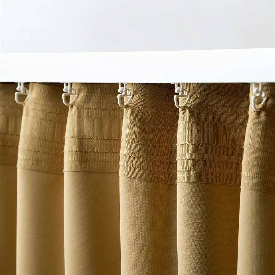 Room darkening curtains hung from ceiling, showing curtain hooks.