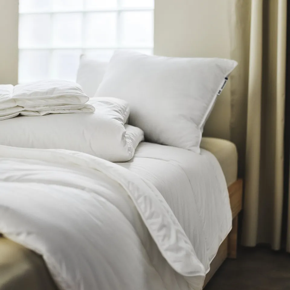 Bed with white SKOGSFRÄKEN duvet, soft & fluffy, covers half the bed, neat & clean.
