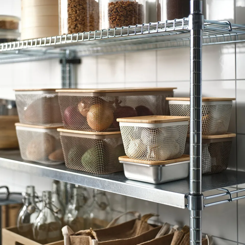 Metal shelving unit with mesh storage bins holding fruits and vegetables.