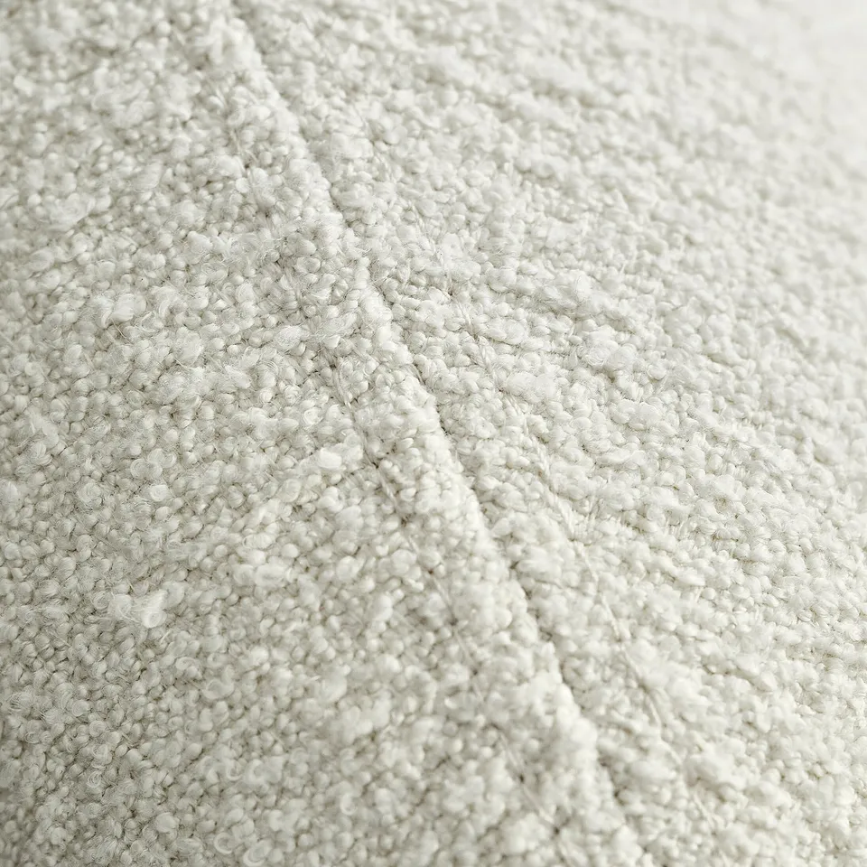 A close-up of a soft, textured, light grey fabric with a looped weave, providing a sense of comfort and quality.