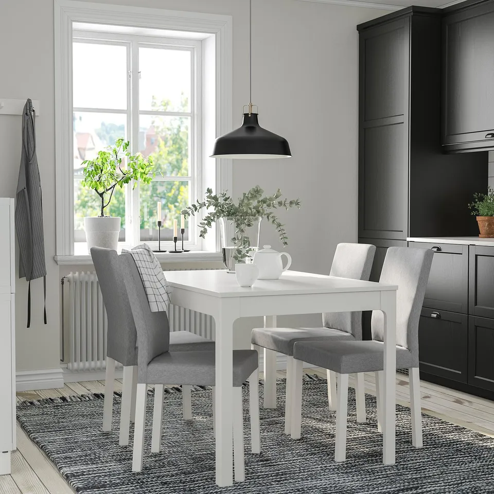 Modern kitchen with KÄTTIL chairs, table, and pendant lamp. Dark cabinets, large window.
