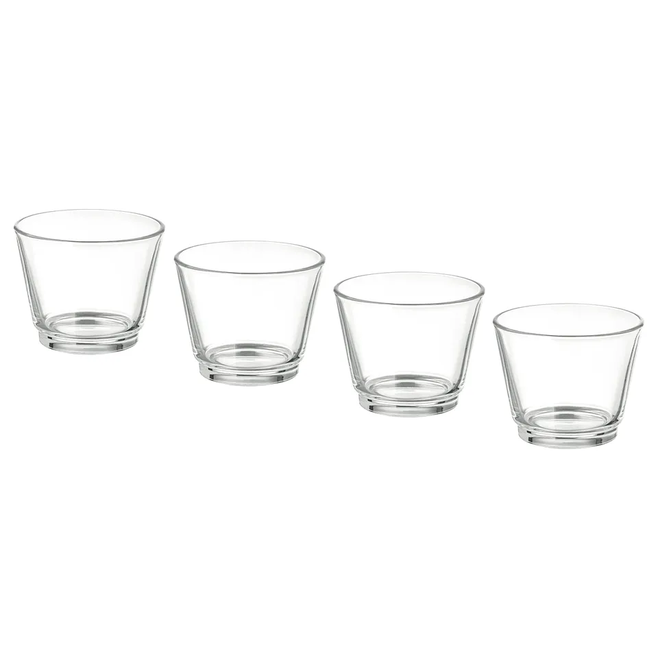 Four clear, stackable glass tealight holders arranged in a line. Simple and sleek design, perfect for holding candles or small plants.