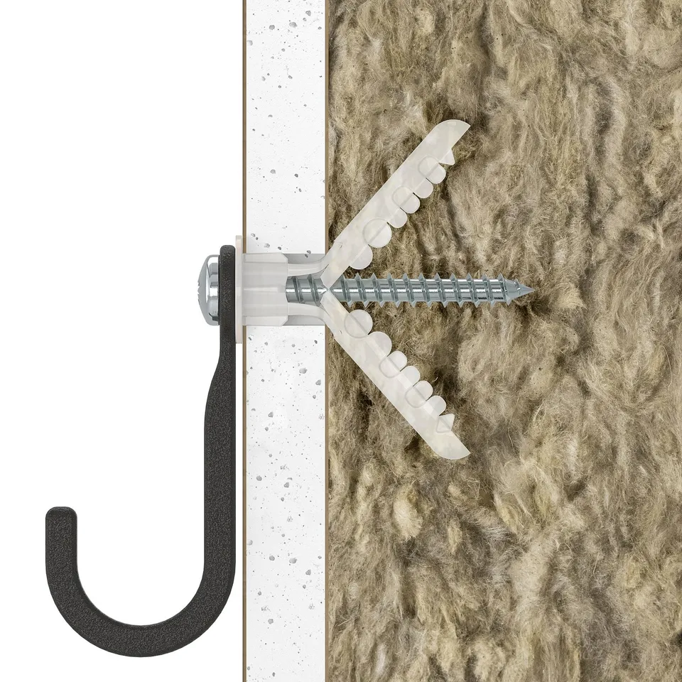Black hook mounted on wall with white fastener. Ideal for organising tools.
