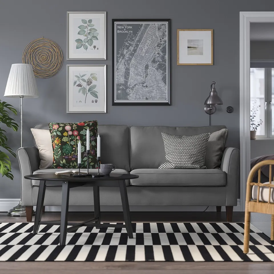 Grey EKHOLMA sofa, dark walls, coffee table, rug, art.