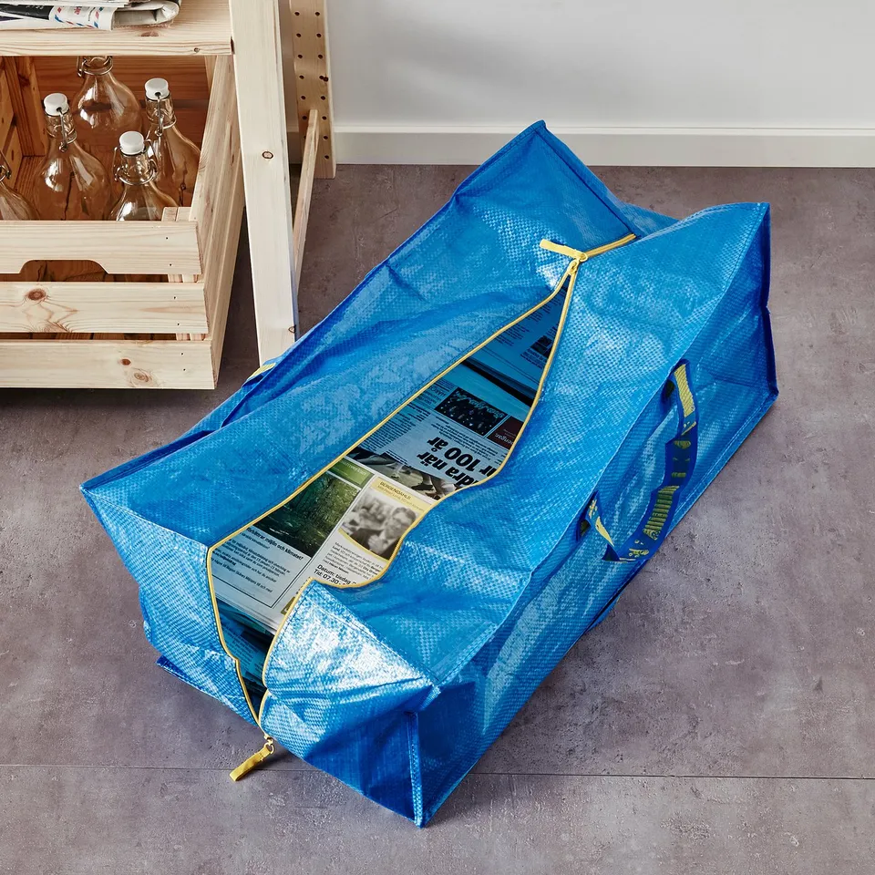 Blue storage bag on floor, handles for carrying.