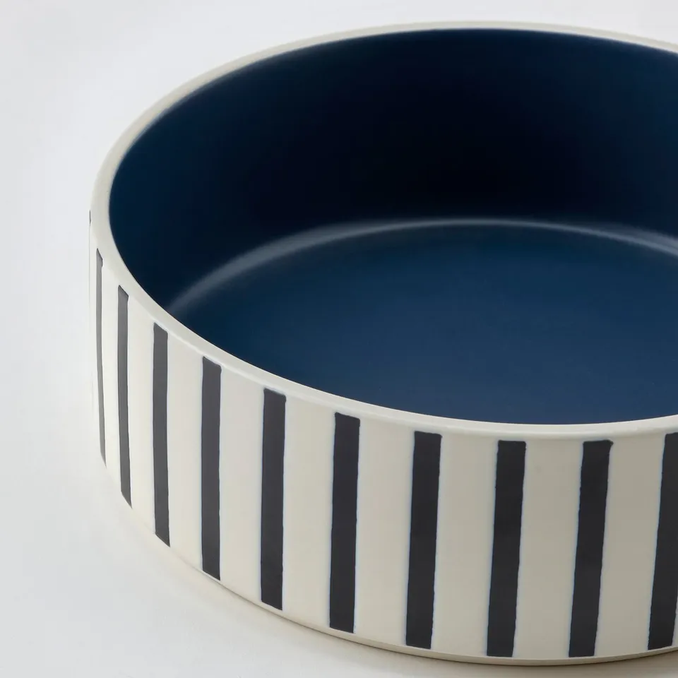 Sturdy UTSÅDD pet bowl with blue interior and black/white striped stoneware exterior.