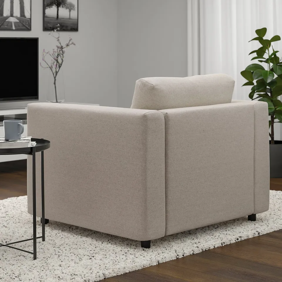 A beige VIMLE armchair with light wood floor and rug. A small table holds a grey mug beside the chair.