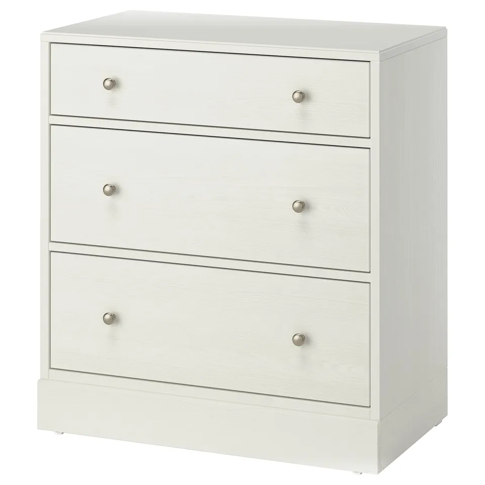 A white HAVSTA chest of drawers with three drawers. Its made of solid pine, has round knobs, and a simple, clean design.