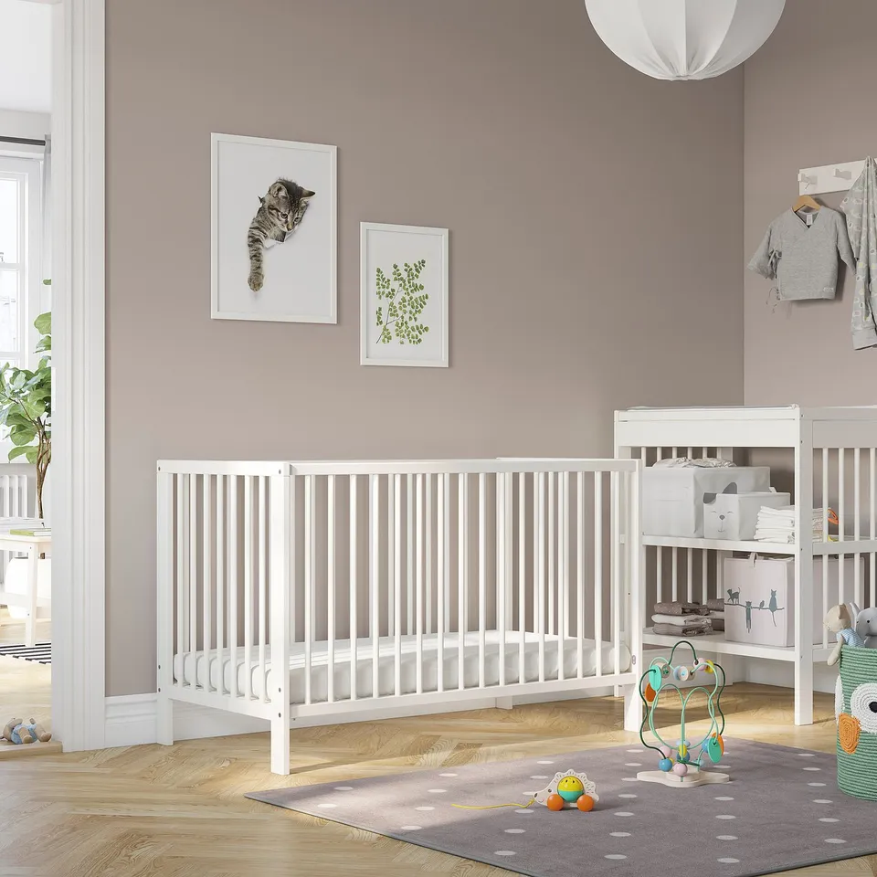 GULLIVER white cot in a nursery; larger than the nearby play mat and toys.