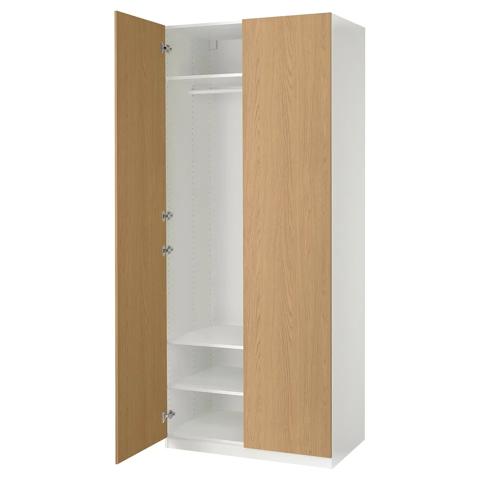 An a light wooden PAX wardrobe with one door open, revealing a hanging rail and shelf inside.