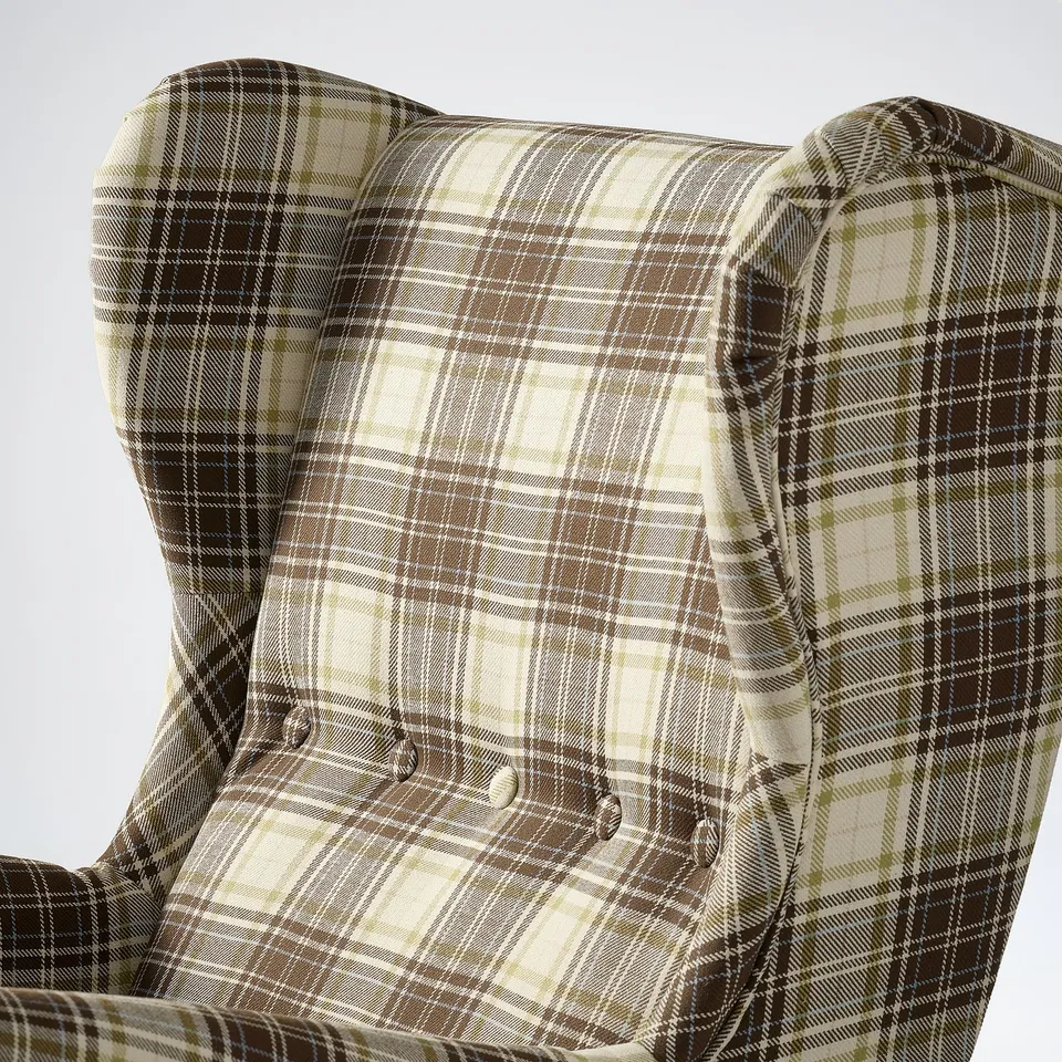 Close-up of a cosy wingback chair with plaid fabric, showcasing its soft, inviting texture and comfortable support.