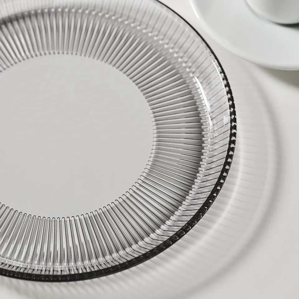 Intricate, patterned glass plate, finely detailed, stackable design.