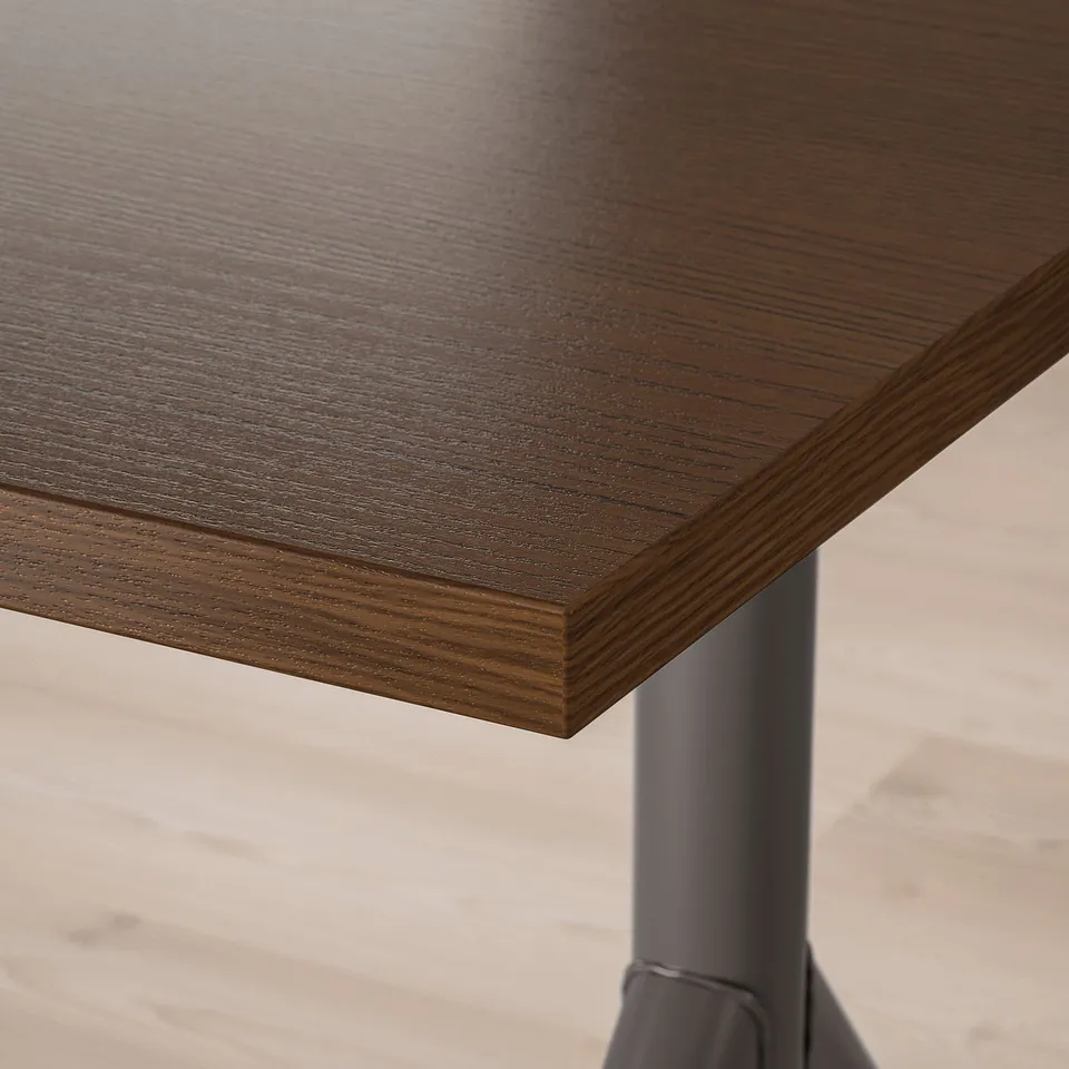A close-up of a dark wooden tabletop with visible fine grain and a sleek, smooth finish.