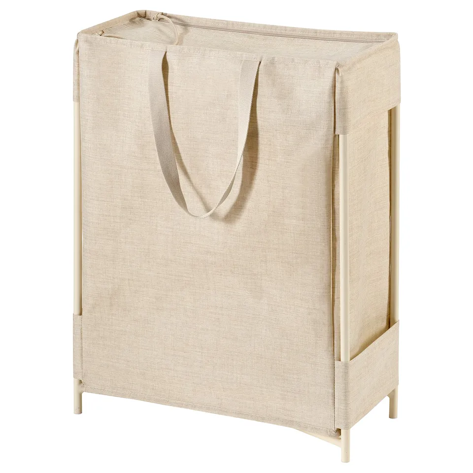 A beige PURRPINGLA laundry basket with a plastic-coated, two-compartment bag. It has sturdy handles and a metal frame for stability.