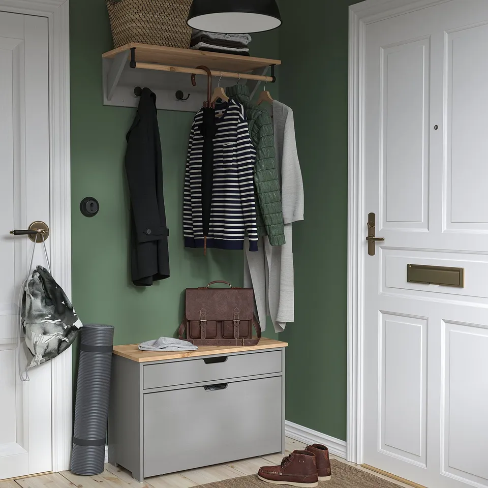 KALLSÖ storage bench with clothes hooks above, brown bag, and rug.