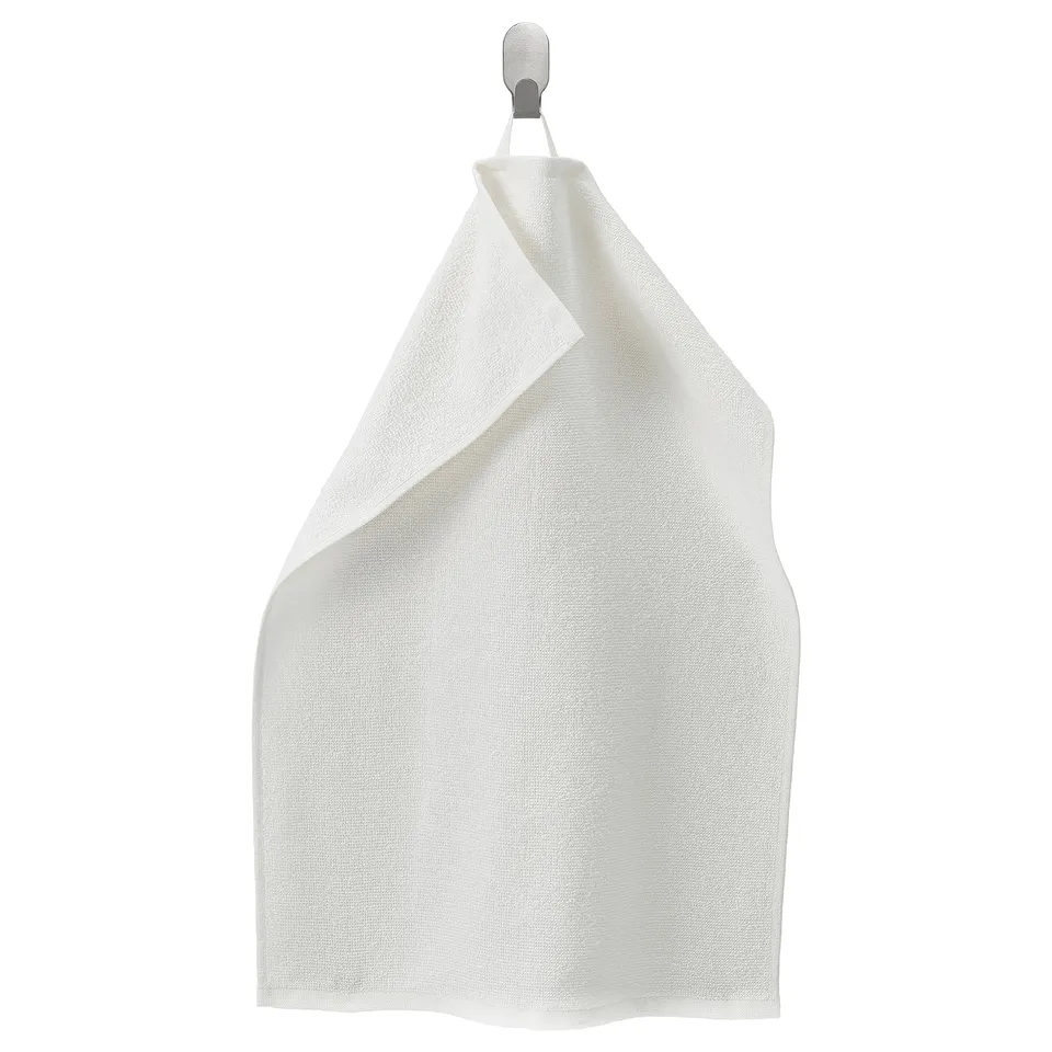 White LUDDVIAL cotton towel hangs neatly on hook, rectangular shape, plain design.
