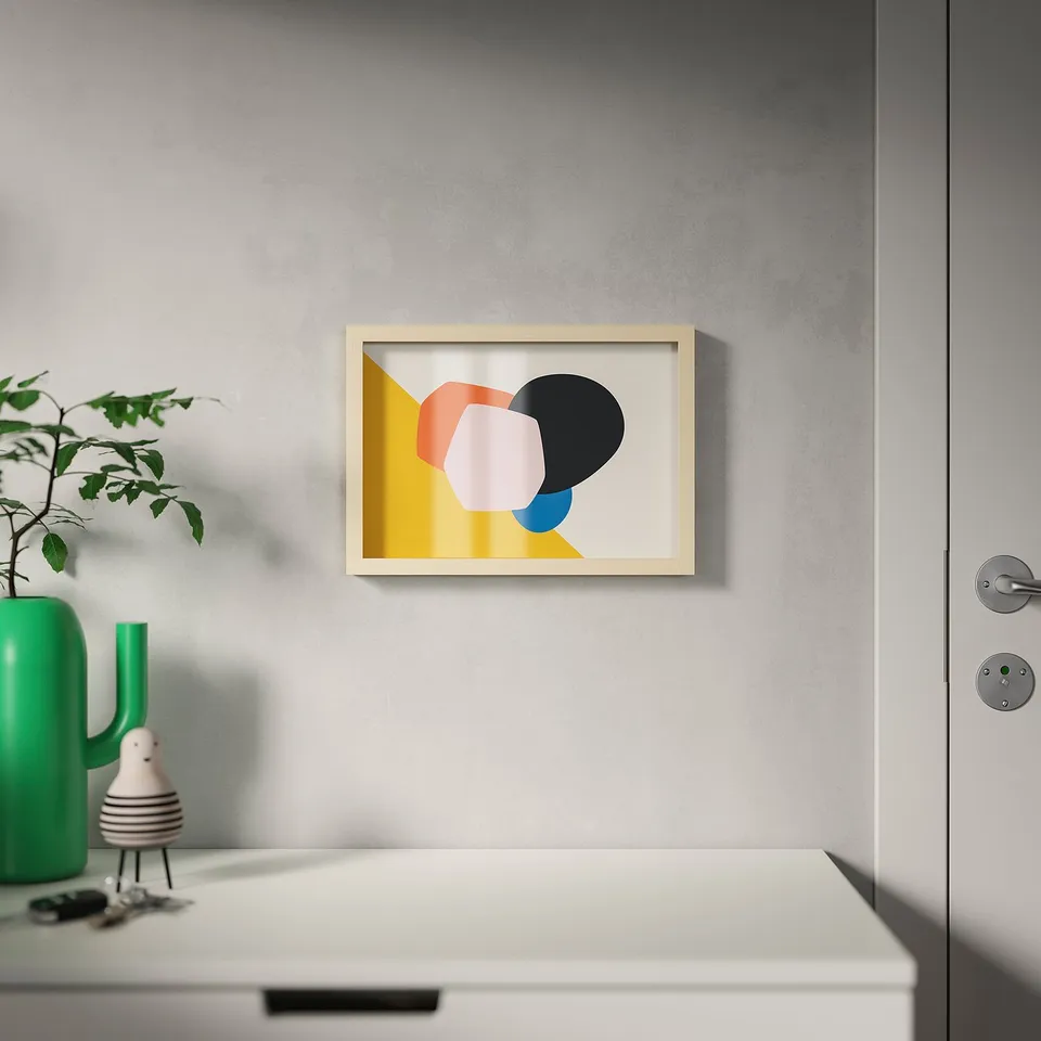 Framed modern art hangs centred on a grey wall above a white drawer. The frame can hang or stand, with various mounting options.