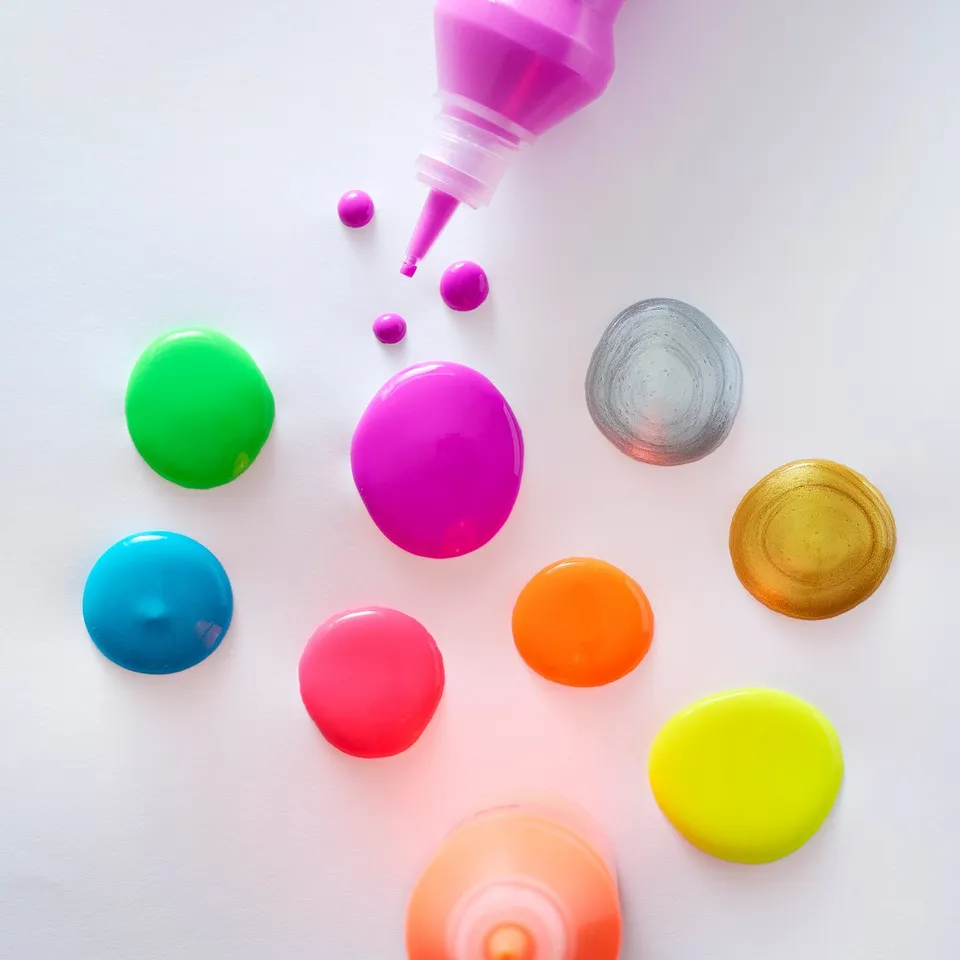 Vibrant paint bottles, one squeezing out pink paint. Perfect for kids to draw, paint with brushes or tips, non-toxic.