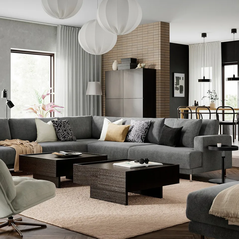 Modern living room with grey sofa, coffee table, rug, lamps, shelf.