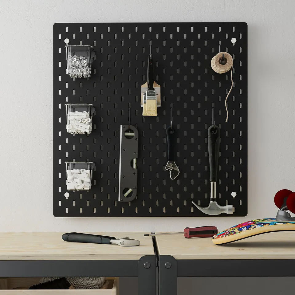 SKÅDIS pegboard with tools and containers above desk and skateboard.
