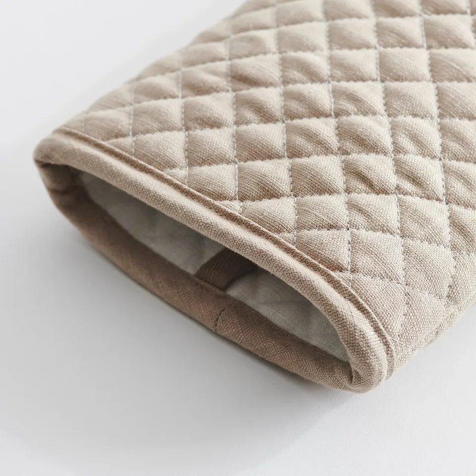 Beige quilted oven glove, soft yet protective, hanging loop visible.