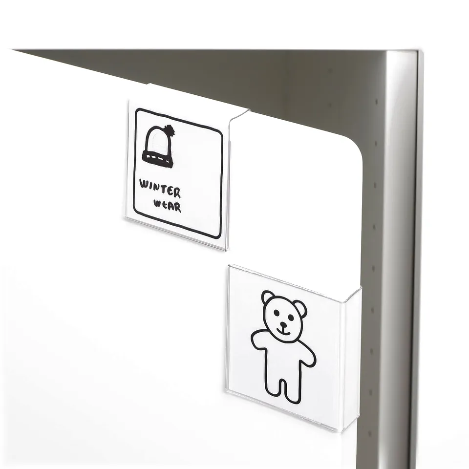 White storage unit with hanging pockets; one has a teddy bear drawing, labelled HÄNGIG.