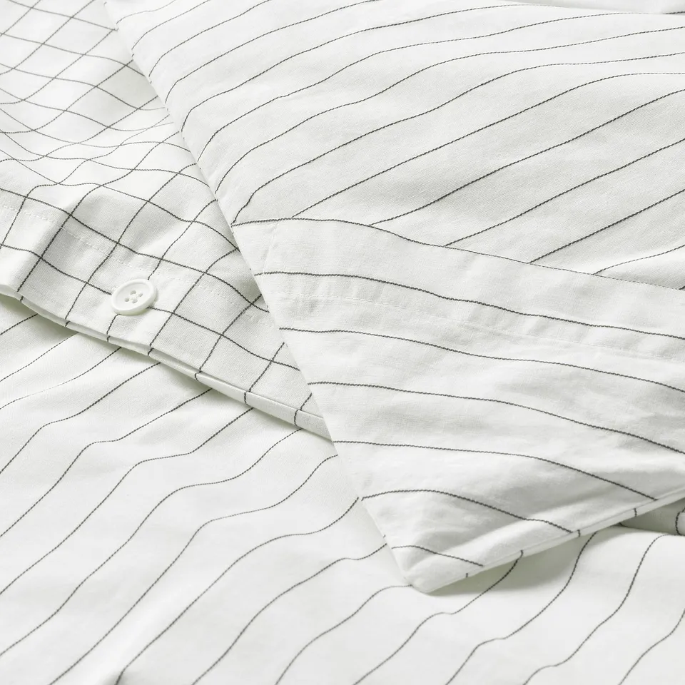 White duvet cover with stitched check and stripes; hidden corner pockets hold duvet in place.