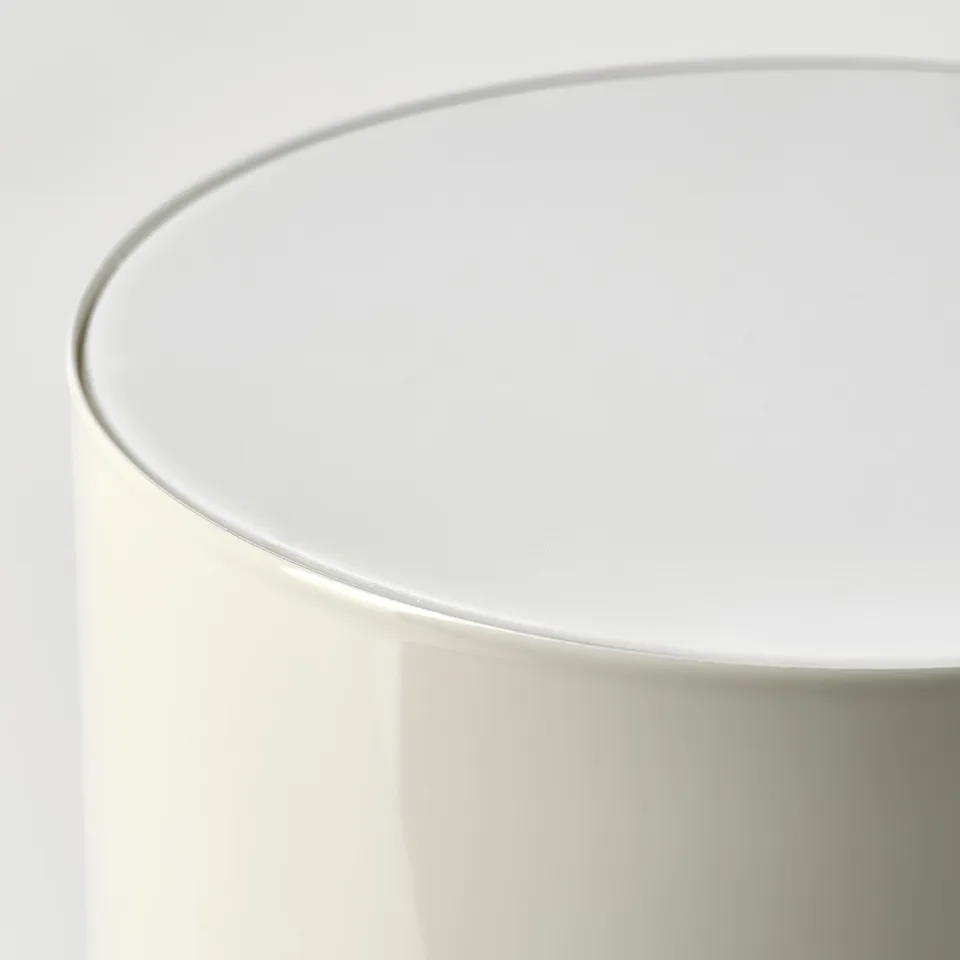 Close-up of a sleek white table lamp, showcasing smooth, rounded design and high-quality finish.