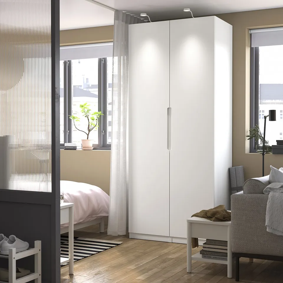 Modern bedroom with large white wardrobe, emphasising storage and simplicity.