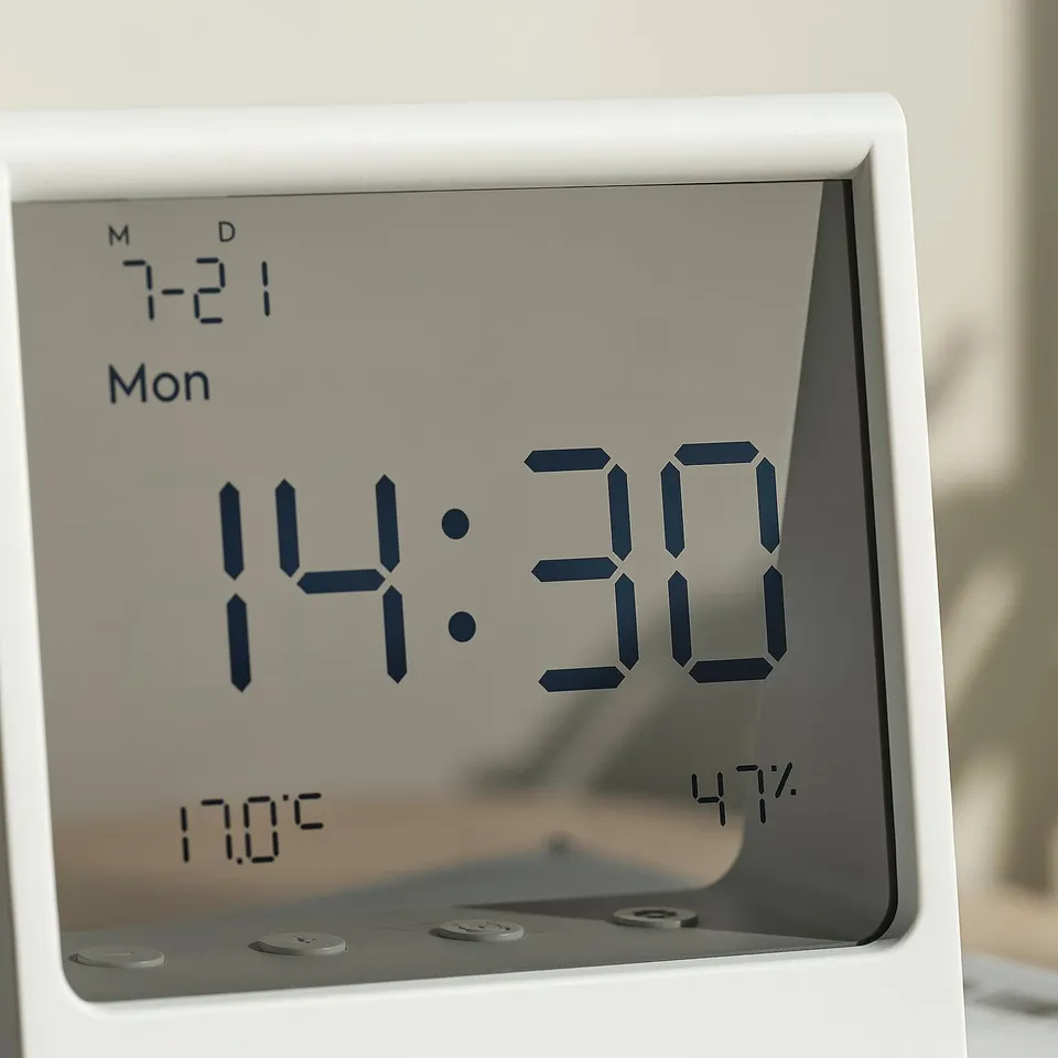 Modern digital clock displaying time, date, temperature, and humidity on clear screen.