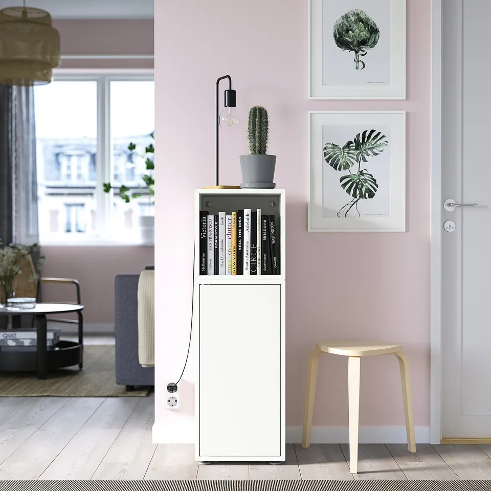 EKET storage unit with cactus, books, stool, plant pictures on pink wall.