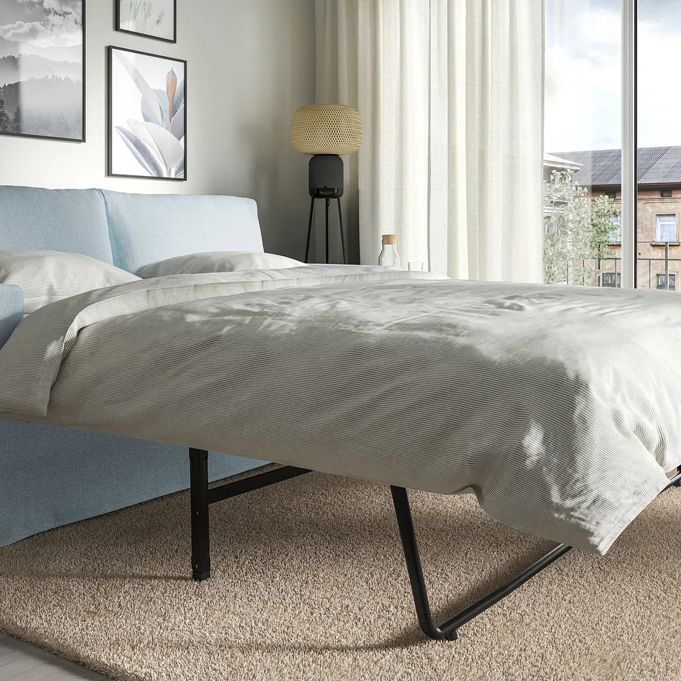 Modern sofa-bed with light grey cover; transforms into a bed.