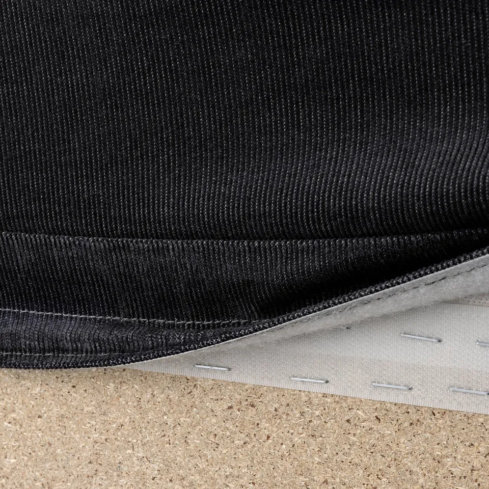 Black sofa fabric with visible stitching and zip, showcasing removable cover for easy cleaning.