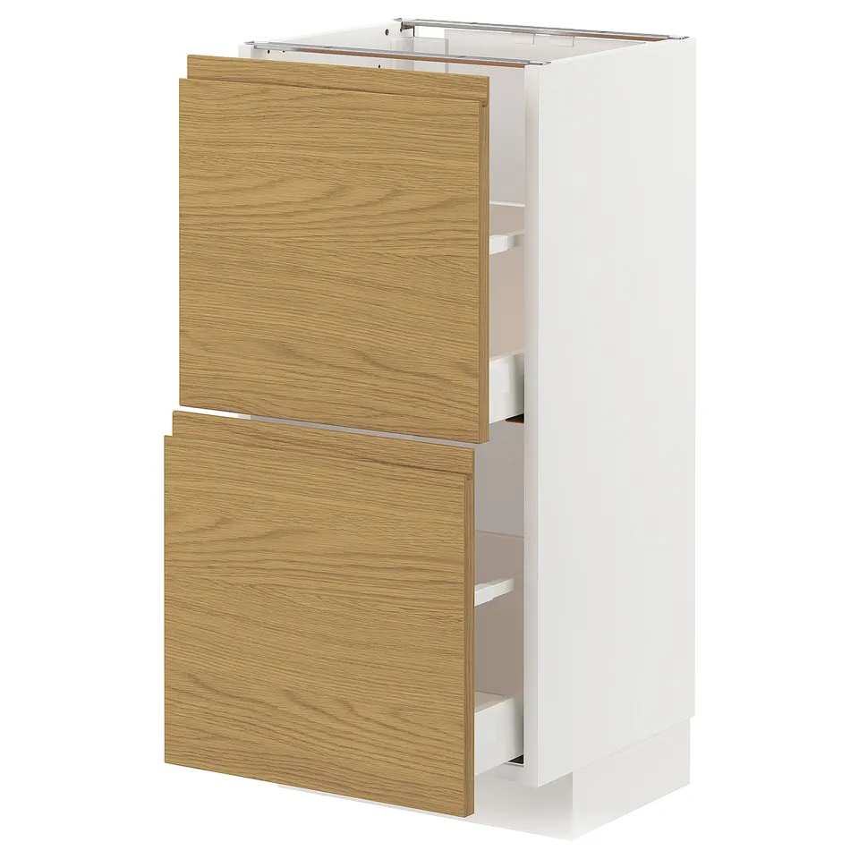 METOD kitchen unit with oak effect drawers and white frame.