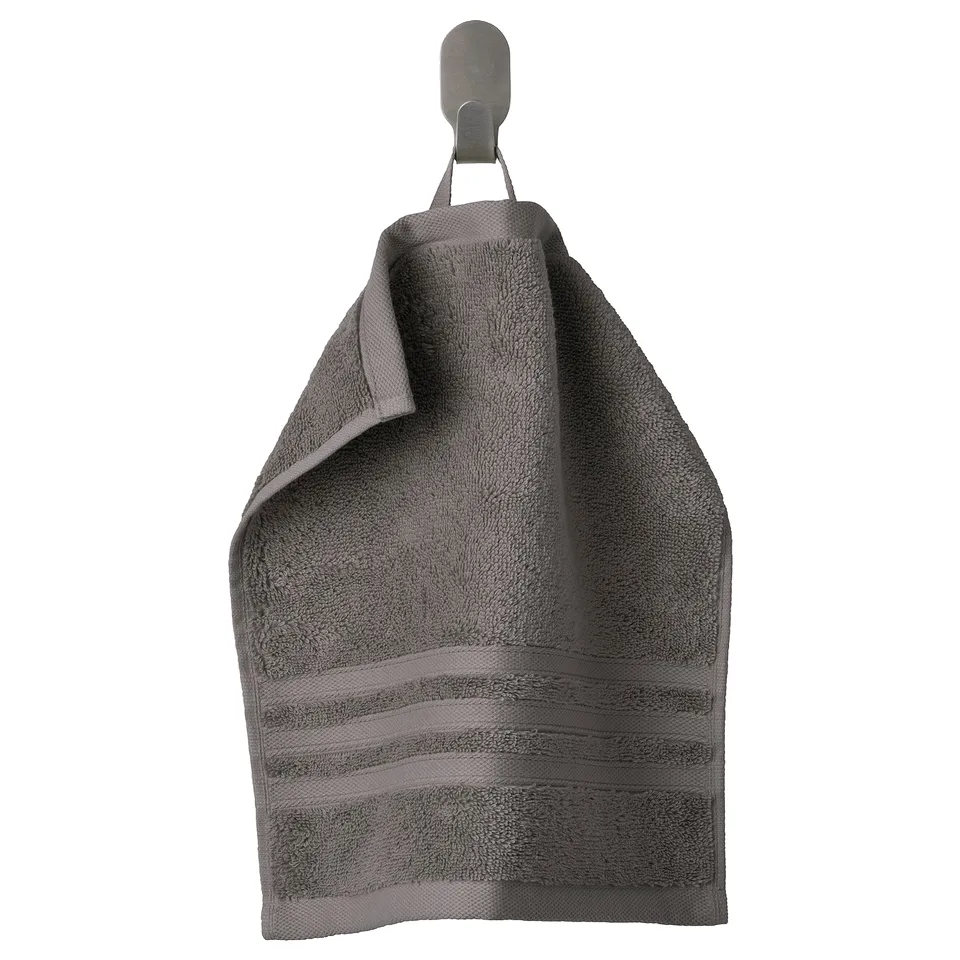 Grey BROKGLIM organic cotton towel hangs neatly on a hook, featuring textured stripes.