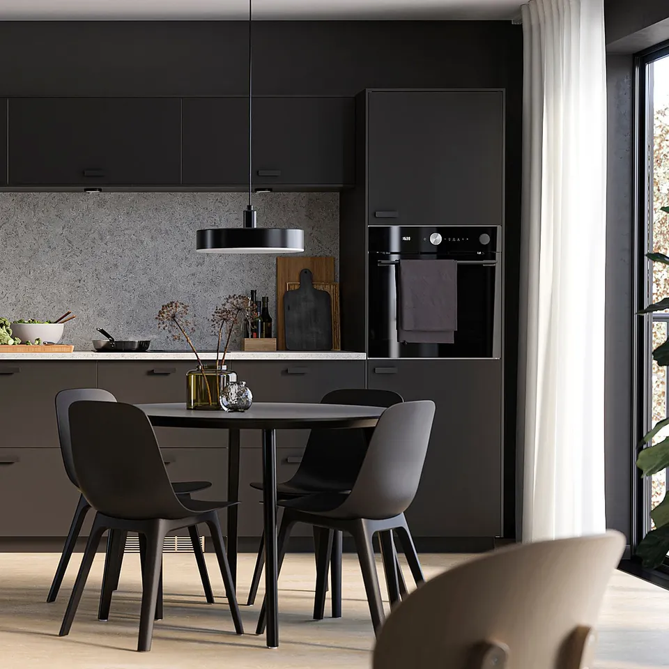 Modern kitchen with matt black NICKEBO cabinets, sleek countertops, built-in oven, and dining set with minimalist chairs and table.