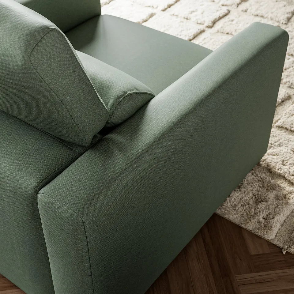 Green modern armchair on wood floor, soft comfortable fabric, high back, perfect for relaxing.
