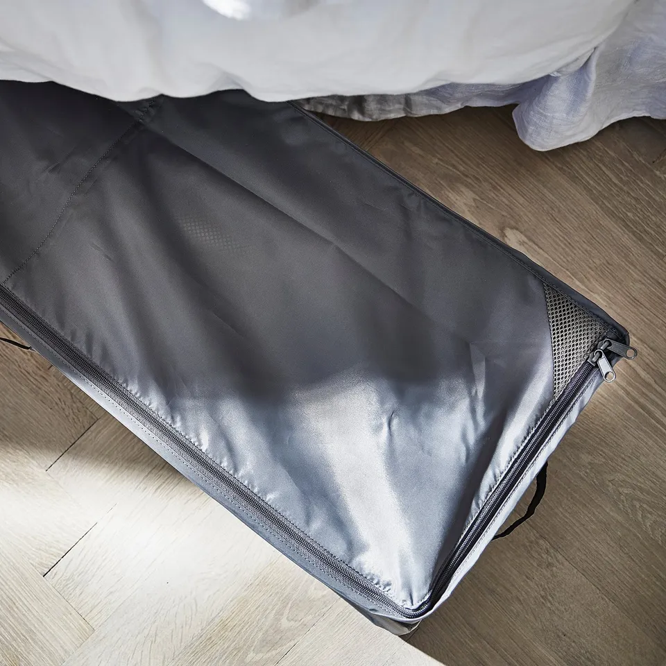 A grey SKUBB storage case on a wooden floor, ideal for organising and protecting items under the bed.